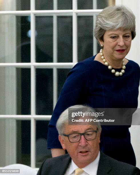 British Prime Minister Theresa May walks past European Commission President Jean-Claude Juncker as they attend an informal dinner ahead of an EU...