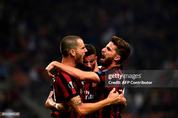 Milan's Argentinian defender Mateo Musacchio celebrates with teammates Leonardo Bonucci and Fabio Borini after scoring during the UEFA Europa League...