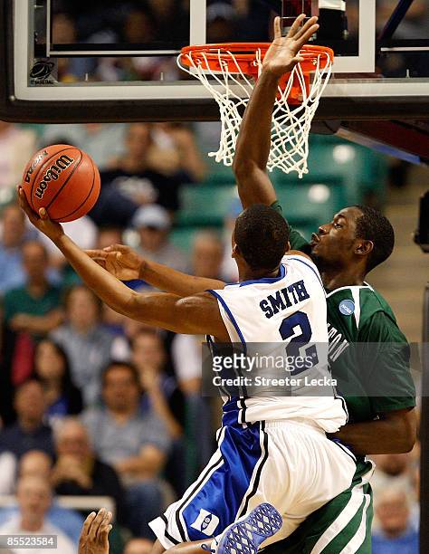 Nolan Smith of the Duke Blue Devils lays in a basket against Kyrie Sutton of the Binghamton Bearcats during the first round of the NCAA Division I...
