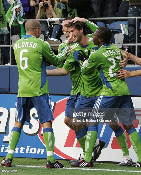 Brad Evans of the Seattle Sounders FC is congratulated by teammates after he scored the Sounders second goal in the first half of the opening match...