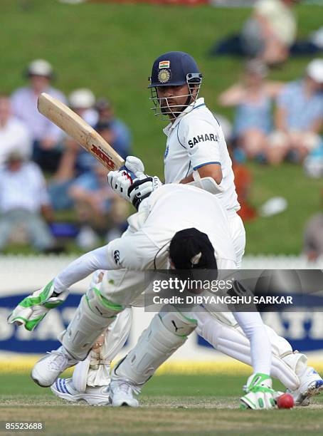 Indian cricketer Sachin Tendulkar plays a shot as New Zealand wicket keepet Drendon McCullum attempts to stop the ball during the third day of the...