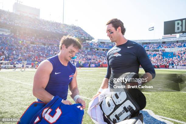 Colt Anderson of the Buffalo Bills and Brock Osweiler of the Denver Broncos trade jerseys after the game on September 24, 2017 at New Era Field in...