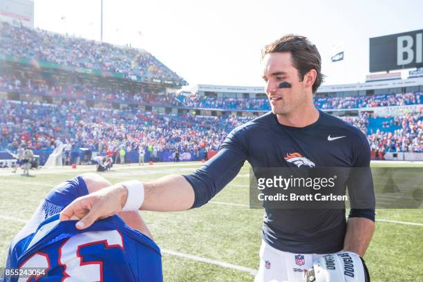Colt Anderson of the Buffalo Bills and Brock Osweiler of the Denver Broncos trade jerseys after the game on September 24, 2017 at New Era Field in...
