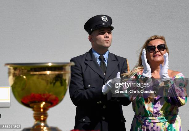 Cheryl Lee and Mark Lee Jr., honoring Fire Captain Mark Lee Sr., of Engine Company 10, walk to the first tee during the first round of the Presidents...