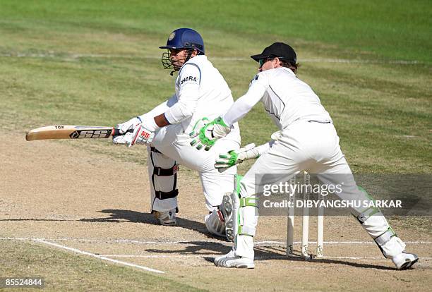 Indian cricketer Zaheer Khan plays a shot as New Zealand wicketkeeper Brendon McCullum looks on during the third day of the first Test match between...