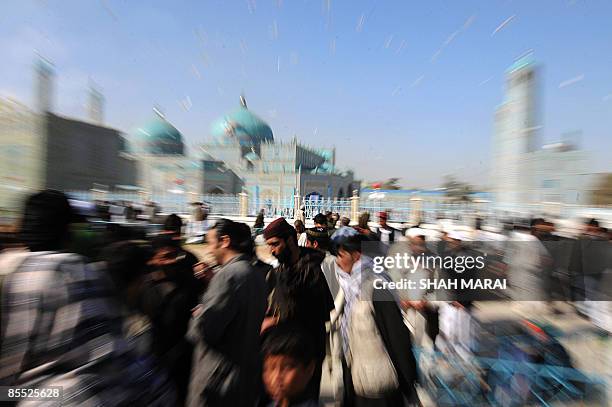 Afghan devotees walk at the Hazrat Ali Shrine in Mazar-i-Sharif on March 20, 2009. Tens of thousands of Afghans from all over the war-scarred country...