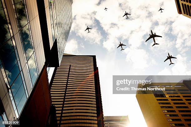 airplanes flying over buildings - low angle view of airplane stock pictures, royalty-free photos & images