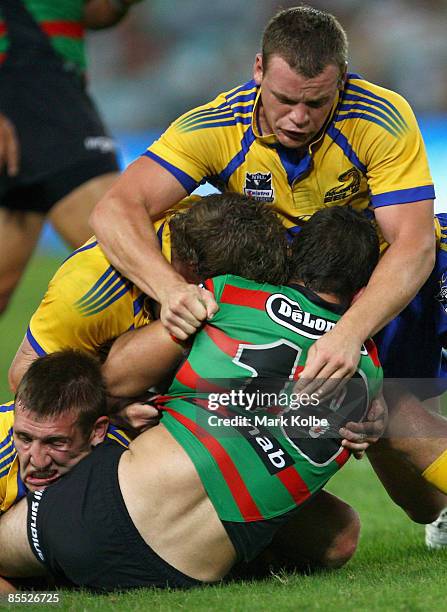 Jamie Simpson of the Rabbitohs is wrapped up by the Eels during the round two NRL match between the South Sydney Rabbitohs and the Parramatta Eels at...