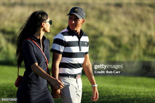 Rickie Fowler of the U.S. Team and girlfriend Allison Stokke walk on the 17th hole during Thursday foursome matches of the Presidents Cup at Liberty...