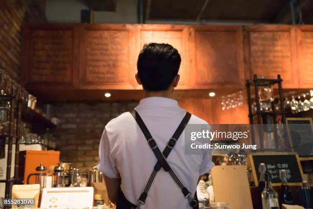 barista in working in cafe - schürze mann rückansicht stock-fotos und bilder