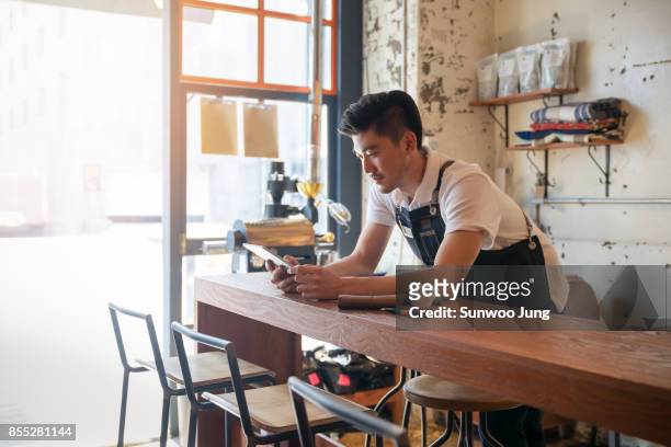 small business owner working in the cafe - korean man stockfoto's en -beelden