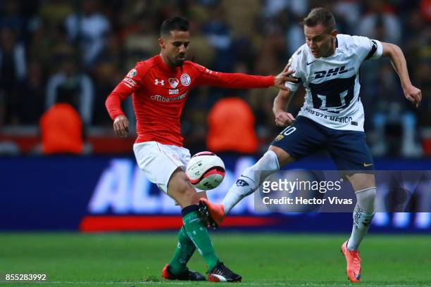 Rodrigo Lopez of Toluca struggles for the ball with Abraham Gonzalez of Pumas during the 11th round match between Toluca and Pumas UNAM as part of...