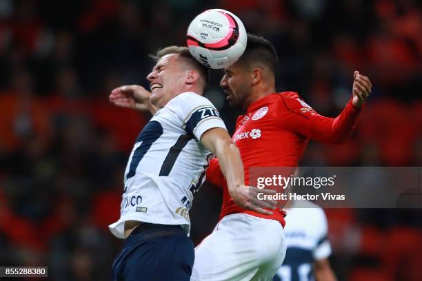 Rodrigo Lopez of Toluca jumps for a header with Abraham Gonzalez of Pumas during the 11th round match between Toluca and Pumas UNAM as part of the...