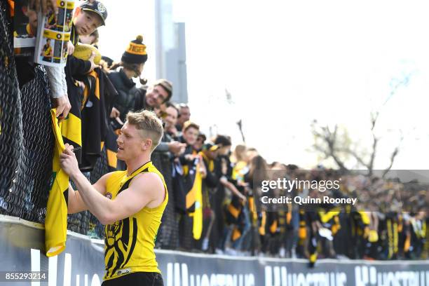 Josh Caddy of the Tigers signs autographs during a Richmond Tigers AFL training session at Punt Road Oval on September 29, 2017 in Melbourne,...