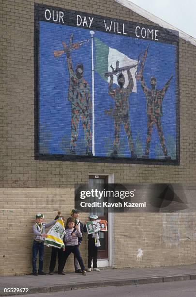 Group of boys stand under a pro-IRA mural in the Catholic neighborhoods of west Belfast, 17th September 1985.