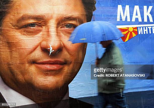 Pedestrian walks past a large election billboard of the main presidential candidate of opposition SDSM party Ljubomir Frckoski in the main square in...