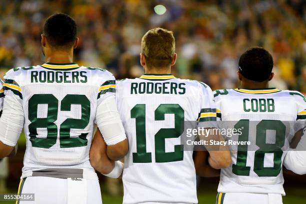 Richard Rodgers, Aaron Rodgers , and Randall Cobb of the Green Bay Packers link arms during the singing of the national anthem before the game...