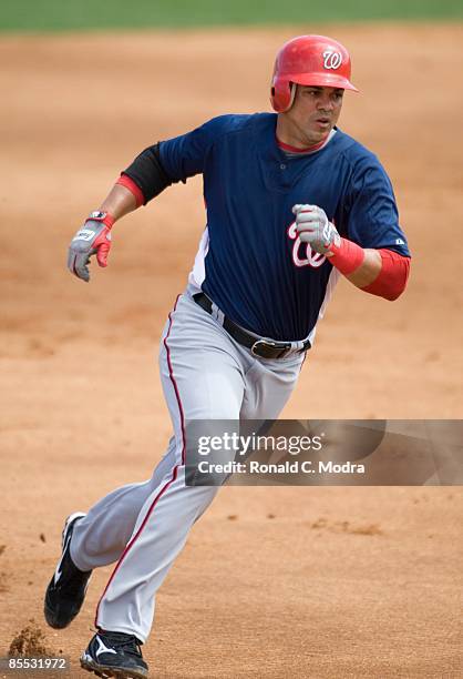 Alex Cintron of the Washington Nationals rounds third base against the Florida Marlins during a spring training game at Roger Dean Stadium on March...