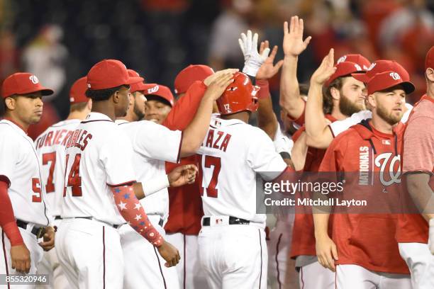 Alejandro De Aza of the Washington Nationals celebrates with teammates after getting a game-winning hit in the ninth inning during a baseball game...