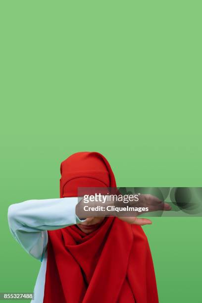 woman in hijab hiding face - cliqueimages stock-fotos und bilder
