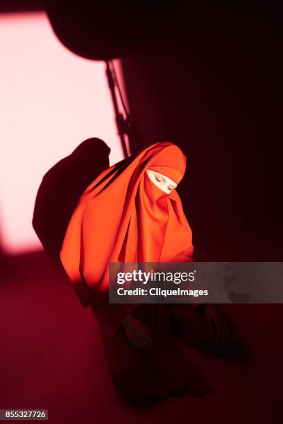 mysterious woman in red niqab - cliqueimages 個照片及圖片檔