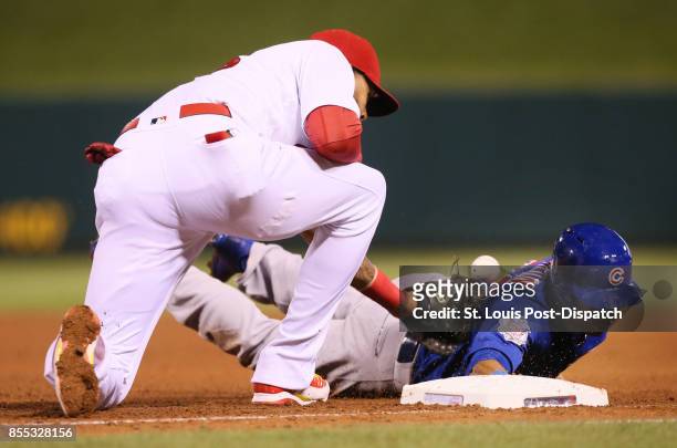 The Chicago Cubs' Leonys Martin, right, returns safely to first base as St. Louis Cardinals first baseman Jose Martinez is unable to catch the...