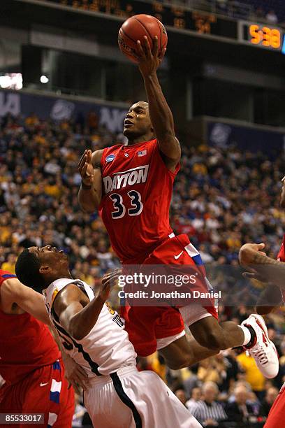 Chris Wright of the Dayton Flyers drives for a shot attempt against Wellington Smith of the West Virginia Moutaineers during the first round of the...