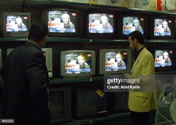 Palestinians watch Al-Jazeera television as it shows the videotaped will of one of the men who carried out the September 11th attacks pledging to die...