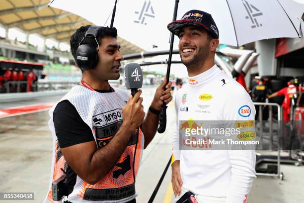 Daniel Ricciardo of Australia and Red Bull Racing talks with Karun Chandhok in the Pitlane during practice for the Malaysia Formula One Grand Prix at...