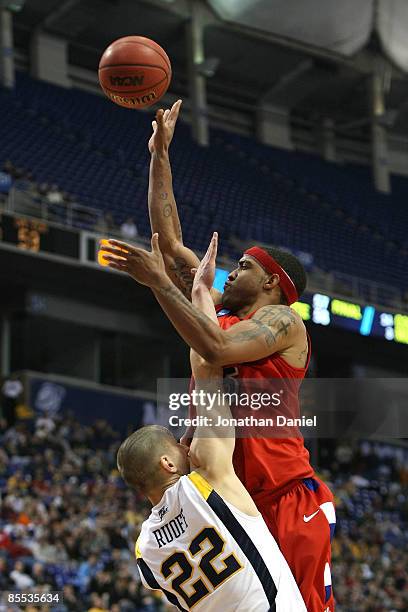 Charles Little of the Dayton Flyers attempts a shot against Alex Ruoff of the West Virginia Moutaineers during the first round of the NCAA Division I...