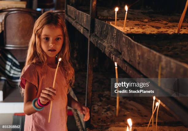 girl is holding candle in the church - innocent imagens e fotografias de stock