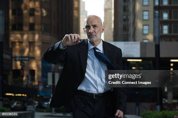 businessman walking along a street - man on wall street stock pictures, royalty-free photos & images