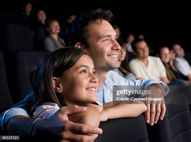 father and daughter watching a movie - children in cinema fotografías e imágenes de stock