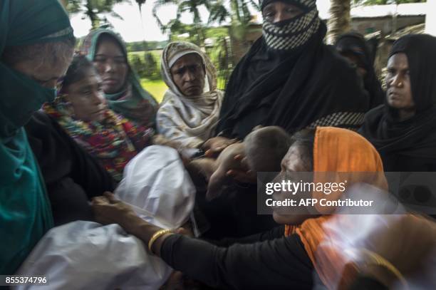 Bangladeshi women wrap up the bodies of Rohingya Muslim refugees at a school near Inani beach in Cox's Bazar district on September 29, 2017. More...