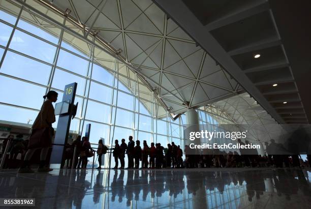 people entering airplane at gate of modern airport - hacer cola fotografías e imágenes de stock