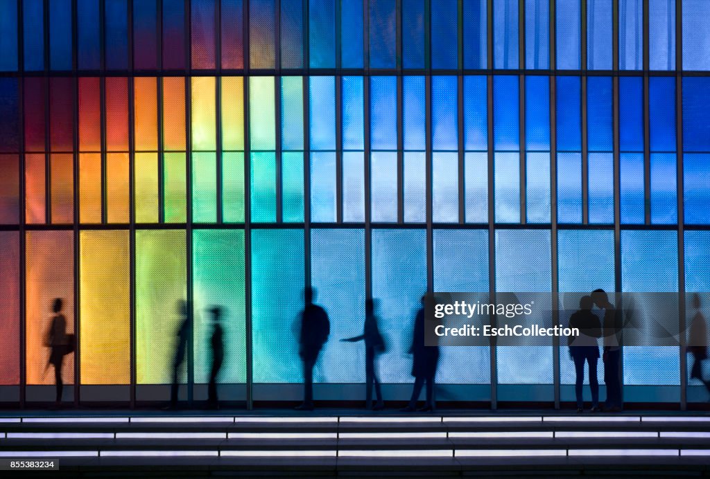 People passing colorful LED illuminated facade