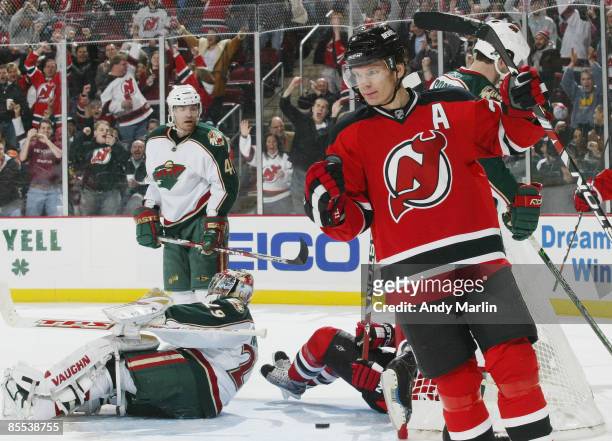 Patrik Elias of the New Jersey Devils pumps his fist after scoring a third period goal as goaltender Josh Harding of the Minnesota Wild lay on the...