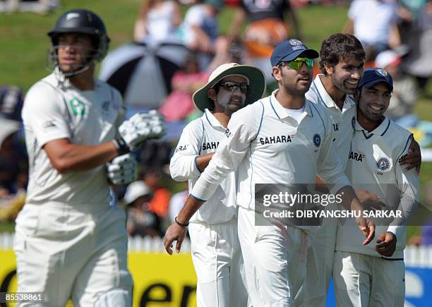 Indian cricketers Dinesh Karthik , Yuvraj Singh and Virender Sehwag congratulate bowler Munaf Patel for taking the wicket of New Zealand batsman Ross...