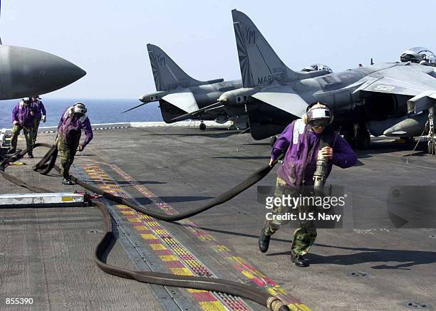 Aviation Boatswain's Mates position JP-5 hoses in preparation to fuel AV-8B Harriers January 11, 2002 aboard the USS Bataan. The aircraft carrier is...
