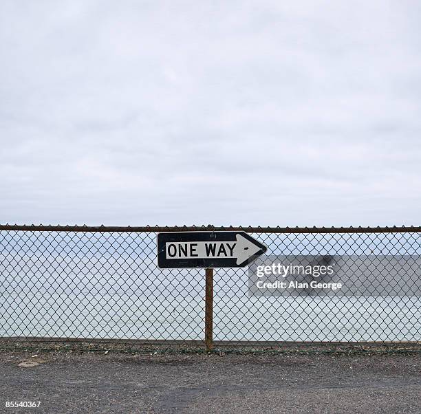 one way sign - wire mesh fence stock-fotos und bilder