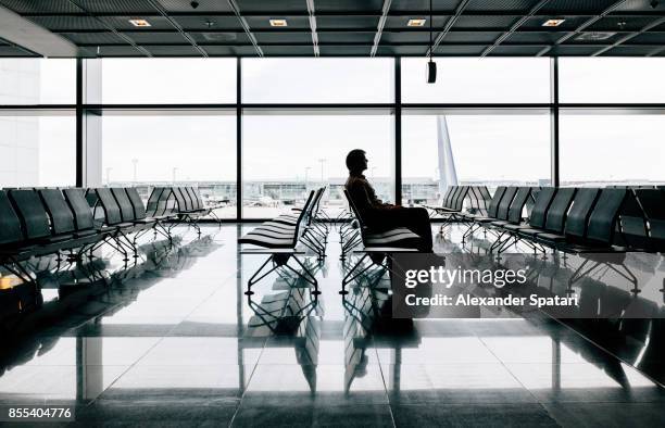 passenger waiting for a flight in an airport - waiting stock-fotos und bilder