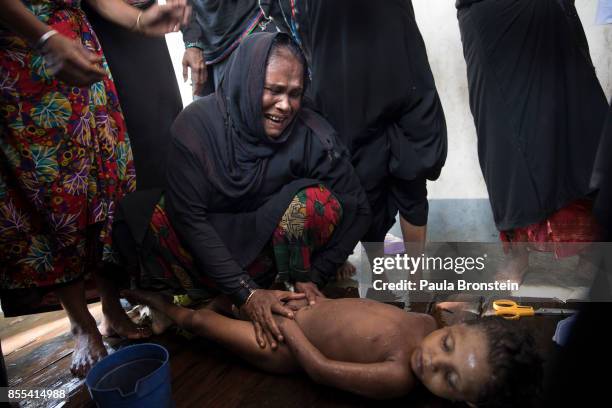 Woman weeps while bathing the bodies of children in preparation for the funeral after a boat sunk in rough seas off the coast of Bangladesh carrying...