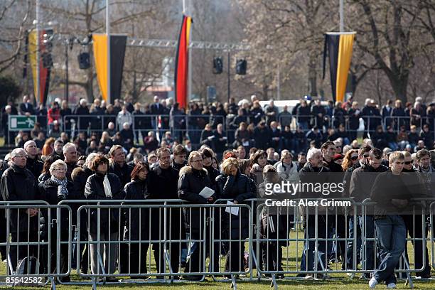 Mourners follow a church service on video screens at a sports field near Albertville high school on March 21, 2009 in Winnenden near Stuttgart,...