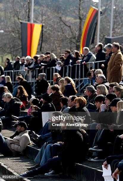 Mourners follow a church service on video screens at a sports field near Albertville high school on March 21, 2009 in Winnenden near Stuttgart,...