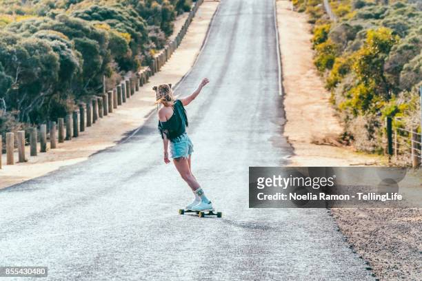 gritty women: woman with a longboard skate - woman longboard stock-fotos und bilder