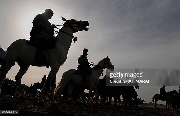 Afghan horsemen prepare to compete over the carcass of headless cattle during Afghanistan's traditional game of Buzkashi in the northern town of...