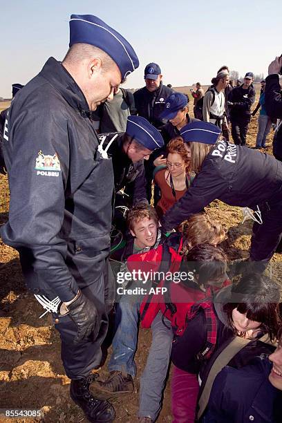 Police stand guard over activists who tried to enter the NATO headquarters on March 21, 2009 during an anti-NATO demonstration in Brussels. The group...