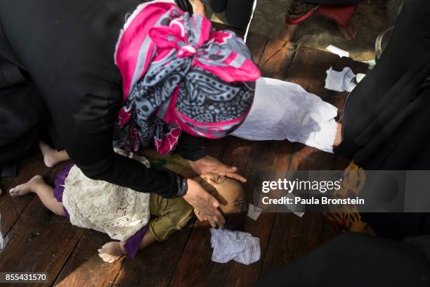 Woman weeps while bathing of the bodies of children in preparation for the funeral after a boat sunk in rough seas off the coast of Bangladesh...