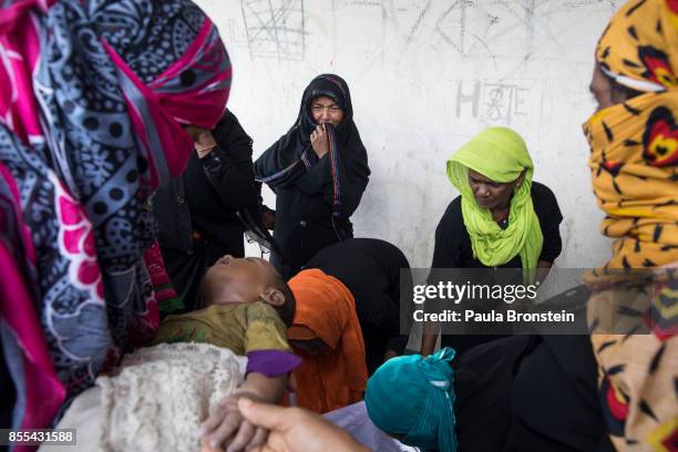 Woman weeps while watching the bathing of the bodies of children in preparation for the funeral after a boat sunk in rough seas off the coast of...