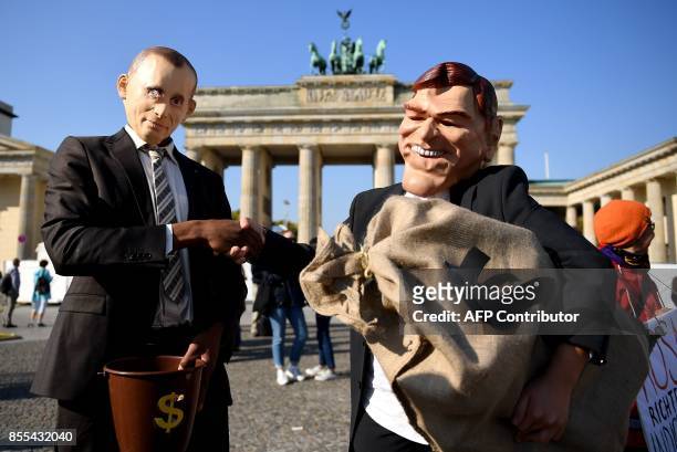 Activists dressed as Russia's President Vladimir Putin and as former German Chancellor Gerhard Schroeder demonstrate on September 29, 2017 in front...